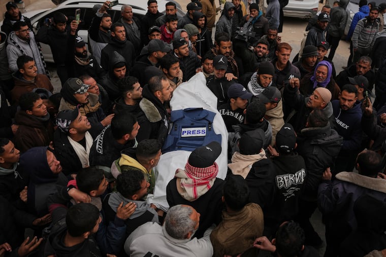 In the Gaza Strip, mourners carry the body of Anas Ghoneim, one of three Palestinian journalists killed in an Israeli strike on an Egyptian committee's vehicle, during his funeral in Khan Younis.