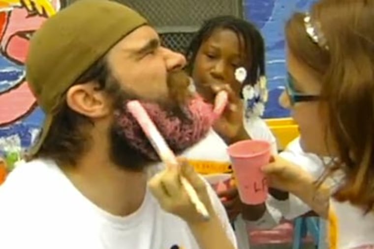 Eagles center Jason Kelce lets students from Comegys Elementary School paint his beard pink.