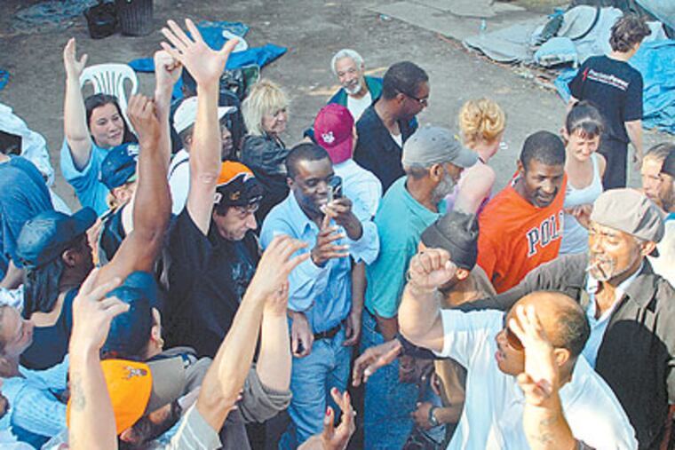 Residents of Camden's Tent City gather for a group cheer early Thursday morning as they begin to take down all the tents before heading to a night in a hotel. (Tom Gralish / Staff Photographer)