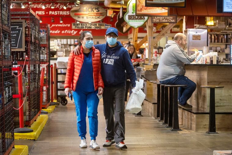 Patrons stroll through Reading Terminal Market wearing masks on Monday morning.