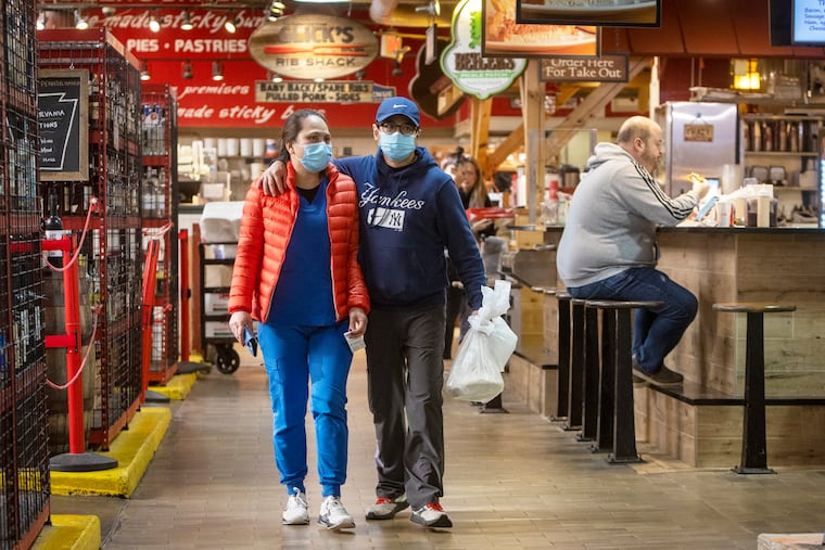 Patrons of Reading Terminal Market, Philadelphia, wearing and not wearing masks on Monday morning.