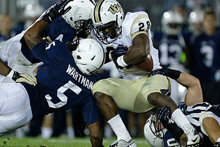 UCF running back William Stanback is brought down by Penn State safety Adrian Amos, linebacker Nyeem Wartman and linebacker Glenn Carson. (Gene J. Puskar/AP)