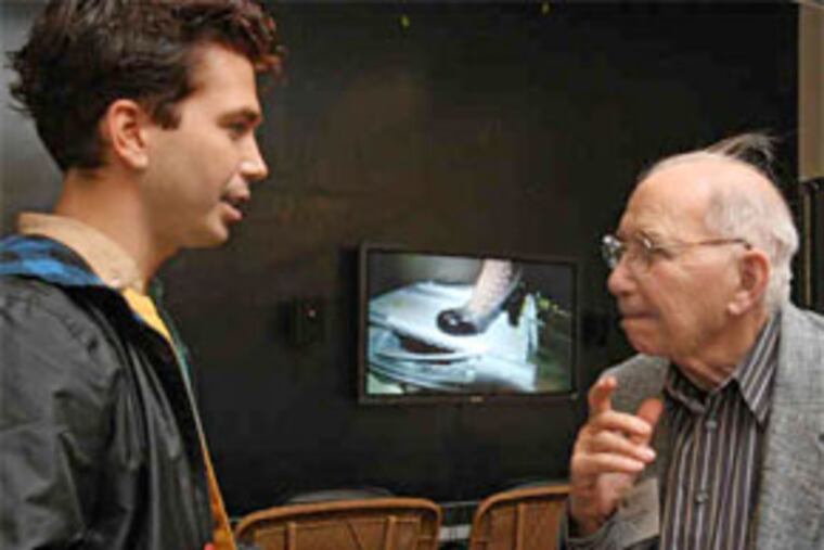 Philadelphia-based multimedia artist Ryan Trecartin (left) has won the first Jack Wolgin International Competition in the Fine Arts. Among his avant-garde works is "P.opular S.ky (section ish)" (2009), which he explains to gallery visitor Herbert Goldberg (right) of Bala Cynwyd. (David M Warren / Staff Photographer)