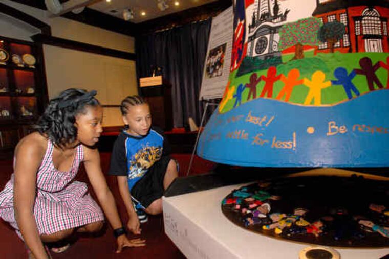At National Liberty Museum, Dy'mon Pendelton (left), 11, and Michael Maguire, 12, of Kenderton School, with their bell. Another decorated Liberty Bell, from Beeber Middle School, is at top.