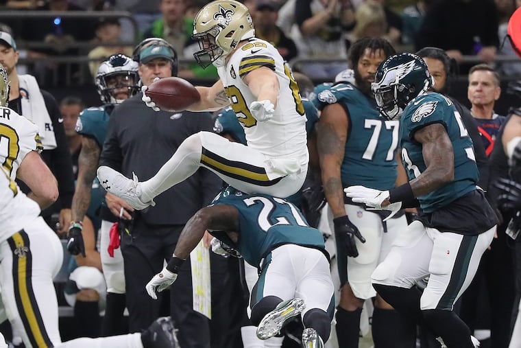 Saints Josh Hill, center, leaps over a tackle by the Eagles Malcolm Jenkins in the 1st quarter as the Philadelphia Eagles play the New Orleans Saints in New Orleans, LA on November 18, 2018. DAVID MAIALETTI / Staff Photographer