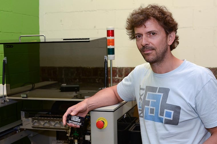 Evan Malone, president of NextFab, with a Pick and Place Machine, which assembles such things as circuit boards.