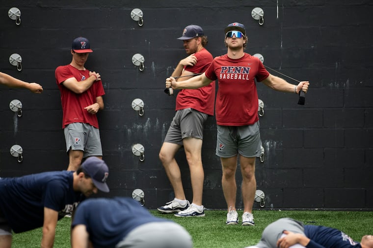 Pitcher and designated hitter Carson Ozmer (right) warms up as Penn prepares for the NCAA Tournament regionals.