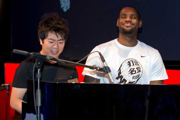 NBA basketball star LeBron James plays piano with renowned pianist Lang Lang, left, during a Nike-sponsored event in Beijing, China, July 21, 2014.