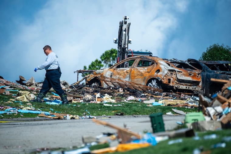 An investigator walks through the debris from a home explosion which occurred the day before in Plum, Pa., on Sunday.