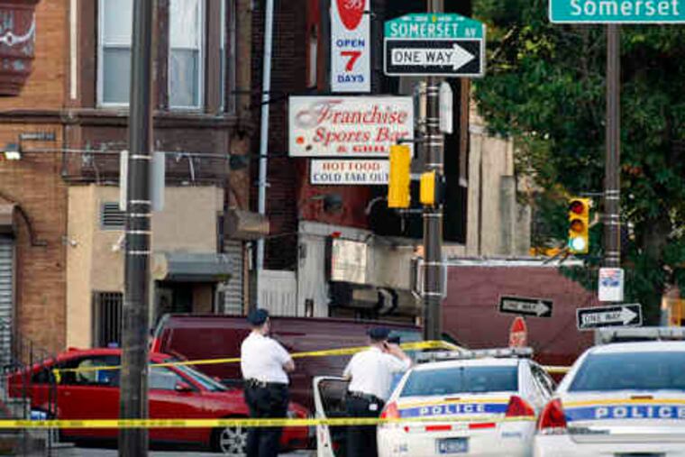 Officers investigate the area around Broad and Somerset Streets where a gun battle beganin the early-morning hours yesterday. Police cordoned off several blocks and diverted traffic.