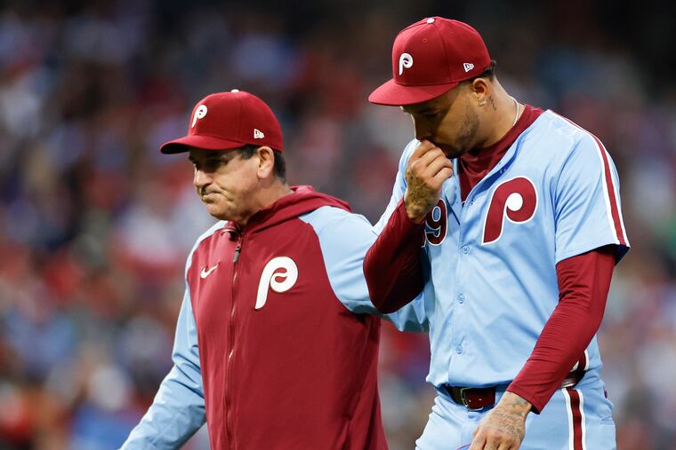 Phillies pitcher Taijuan Walker exits the game with manager Rob Thomson after Walker got hit by a line drive off the bat of New York Mets Starling Marte in the fourth inning.
