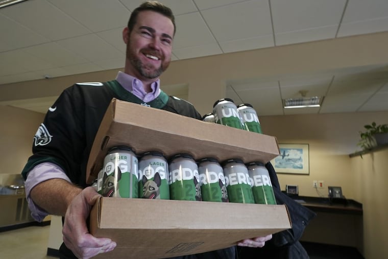 Kevin Smith carries a case of Underdog Lager before his departure for Super Bowl LII from Northeast Philadelphia Airport Saturday.