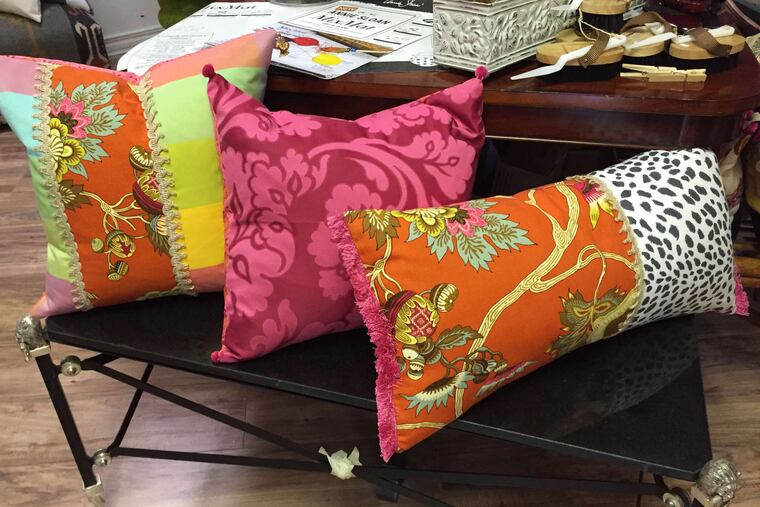 Pillows, above, and an apron, left, from Home on Haddon, among merchants and retailers participating this weekend in Haddonfield's August sidewalk sale, a kind of "outdoor bazaar."