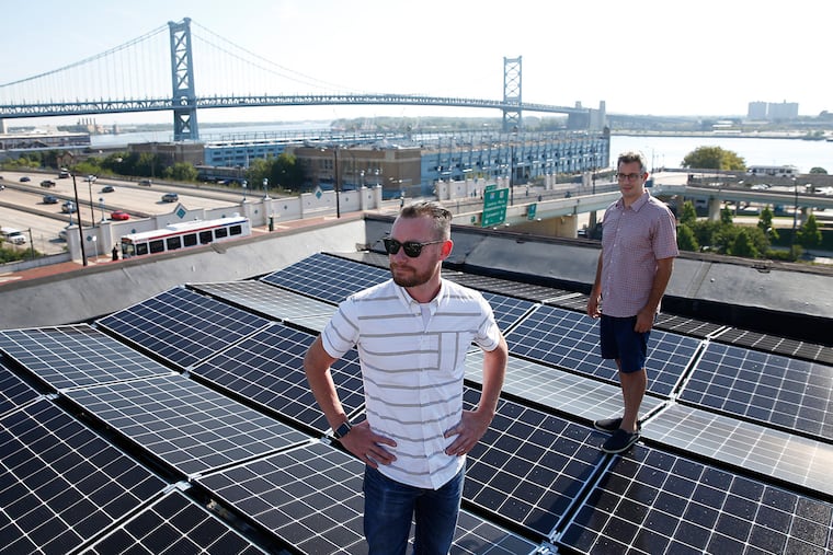 WebLinc cofounder and CEO Darren Hill (left) poses on his 38-panel solar roof with Micah Gold-Markel, founder of Solar States in Philadelphia.
