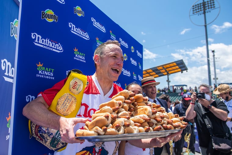 Winners Joey Chestnut and Michelle Lesco, obscured behind hot dogs, posed at the Nathan's Famous Fourth of July International Hot Dog-Eating Contest in Coney Island's Maimonides Park on July 4 in the Brooklyn borough of New York.