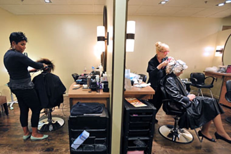 Stylists Seline Braswell, left, and Dottie Cipriotti work on clients at Saks' Premier Salon in Bala Cynwyd. (Sharon Gekoski-Kimmel / Staff)