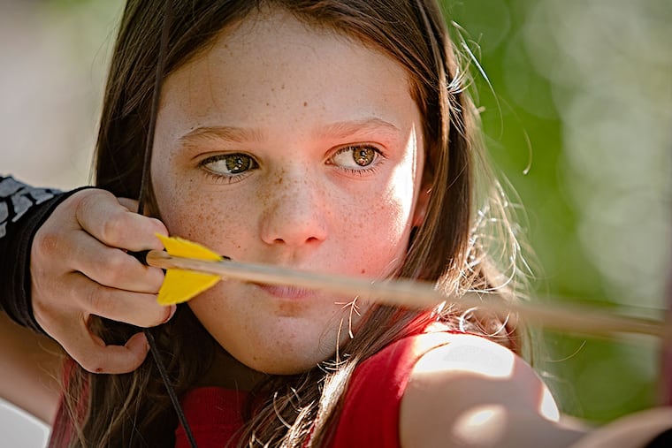 Samantha Klein, draws back her arrow and takes aim at the target on the archery range at Burn Brae Camp in Upper Dublin on July 24, 2015. Burn Brae Camp in Upper Dublin which is offering an old-school camp experience that includes a focus on vintage sports with not a electronic screen in site. ( ED HILLE / staff photographer )
