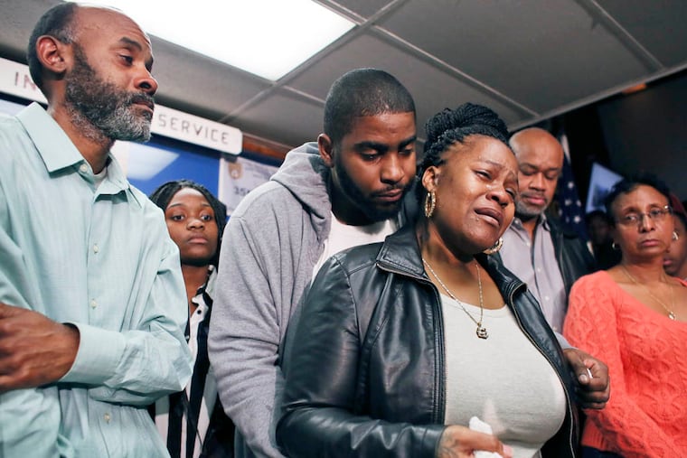 Family members surround Keisha Gaither, third from left, mother of kidnapping victim Carlesha Freeland-Gaither, during a news conference in Philadelphia on Tuesday, Nov. 4, 2014. (AP Photo/ Joseph Kaczmarek)