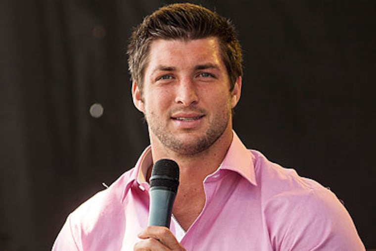 Tim Tebow is deeply religious and doesn't hide it. Quite the opposite. (William Philpott/AP)
