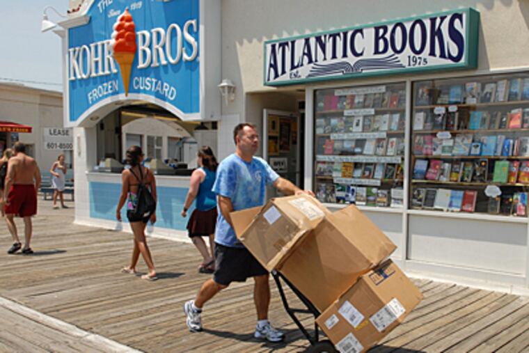 Brent Hanley, owner of the Shirt Shack the Boardwalk in Ocean City, wheels merchandise to his store. (Peter Tobia / Inquirer)