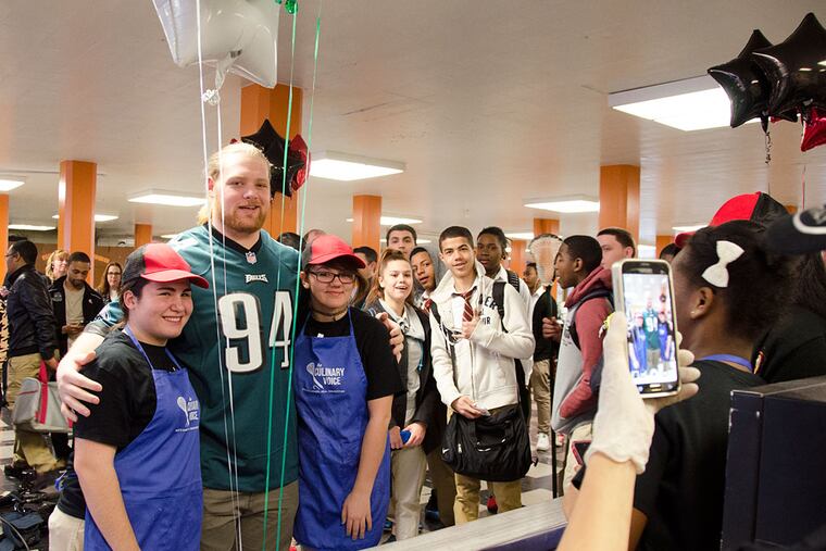 Eagles tackle Beau Allen with Northeast High School students Anna Okropiridze (left) and Jennica Nugent. Both Okropiridze and Nugent are part of the school's new "Wellness Corner," which is responsible for serving healthy breakfasts to students . ( Rachel Wisniewski / Staff Photographer )
