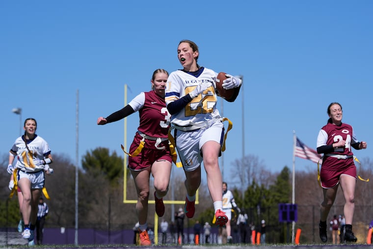 An Augustana University player (front) runs from a Concordia University player during a college flag football game in April 2025.