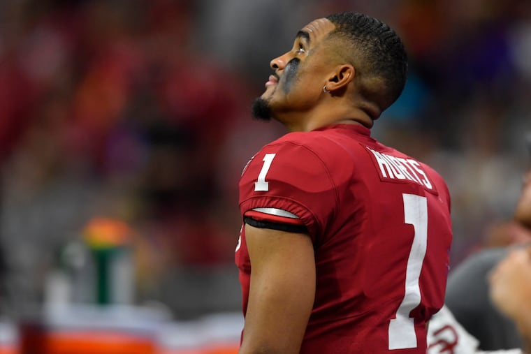 Oklahoma quarterback Jalen Hurts (1) watching a replay against LSU during the second half of the Peach Bowl last December.
