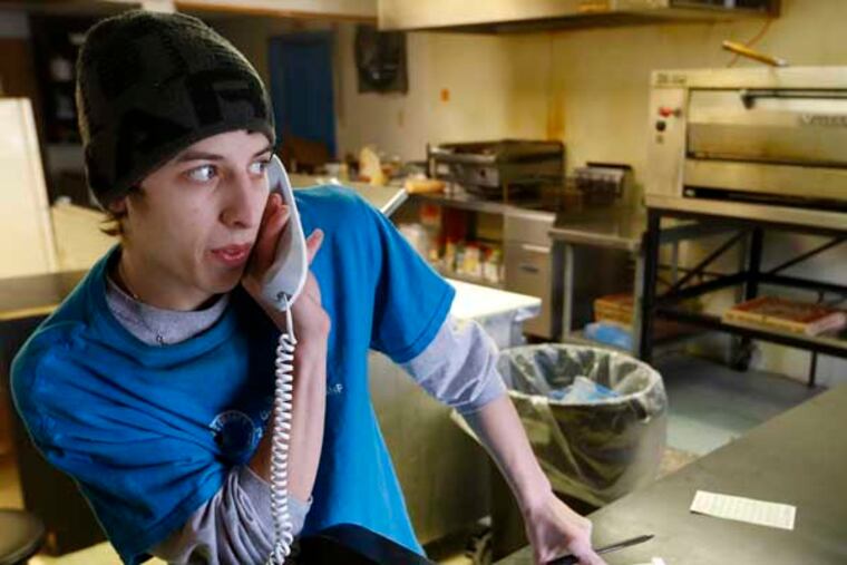Brian Scritchfield takes an order over the telephone at Bobtown Pizza in Bobtown, Pa. The little pizza shop in the southwestern corner of Pennsylvania was placed in the spotlight when energy giant Chevron offered coupons for free pizza from their shop to people who live near the area where a natural gas well that exploded, killing one worker on Feb 11, 2014. Some news stories and internet opinion posts have been critical about the offer by Chevron Corp., but many residents of the town said they didn’t mind the pizza offer. (AP Photo/Keith Srakocic)