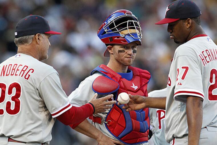 Ryne Sandberg (23) takes the ball from starting pitcher Roberto Hernandez (27) as Koyie Hill (center) looks on against the Pittsburgh Pirates during the sixth inning at PNC Park. The Pirates won 8-2. (Charles LeClaire/USA Today)