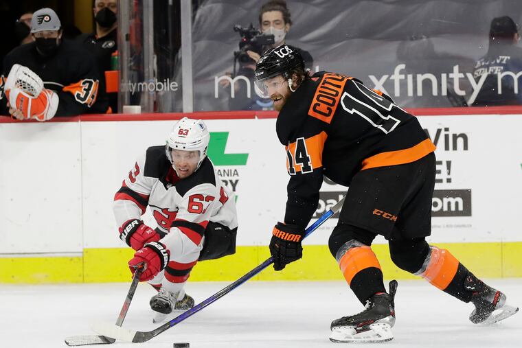 Flyers center Sean Couturier battles for the puck against New Jersey Devils left winger Jesper Bratt during overtime on April 25, 2021. He signed an eight-year extension Thursday.