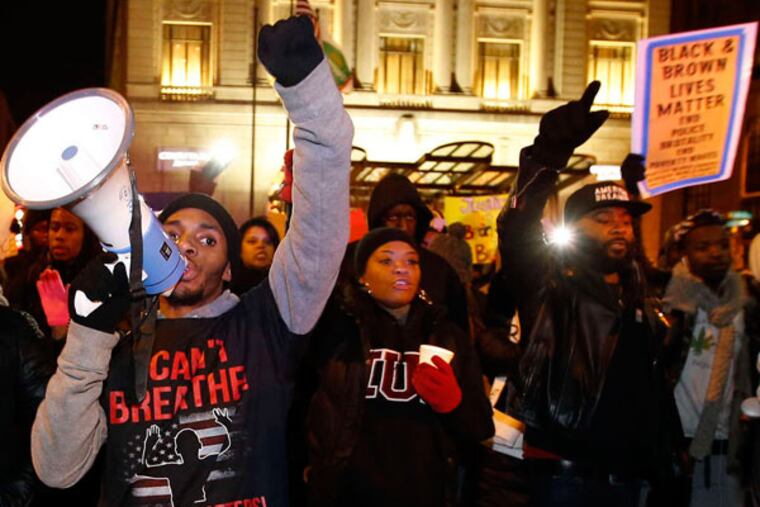 Organizer Raheem Harvey (with megaphone) leads the BlackOut Philly march. "This is not a demonstration to be against police," he said, "but against police brutality." (Yong Kim / Staff Photographer)
