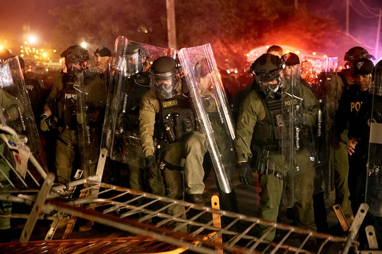Police pass over a barricade as they clash with protesters near the Delaney Hall detention center during a protest against the transfer of detainees and federal immigration policies on Saturday, May 30, 2026, in Newark, N.J. (AP Photo/Andres Kudacki)