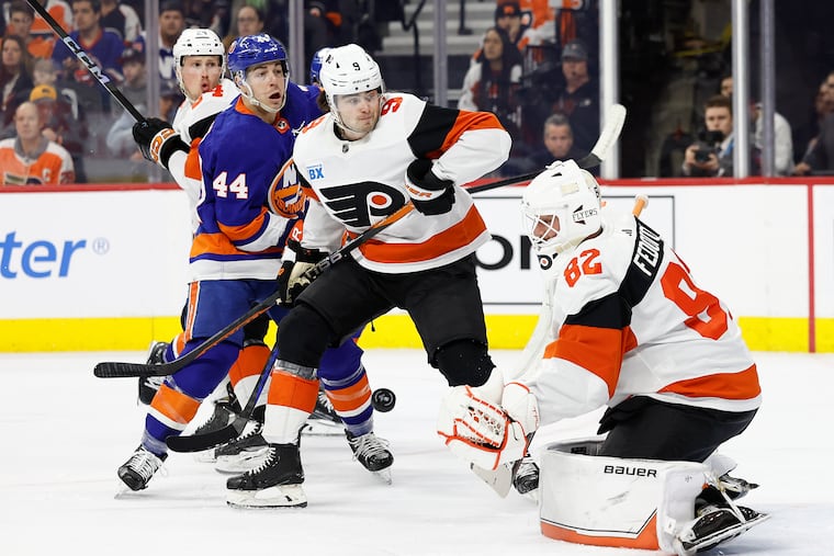 Flyers goaltender Ivan Fedotov watches the puck with teammate defenseman Jamie Drysdale against Islanders center Jean-Gabriel Pageau on Monday.