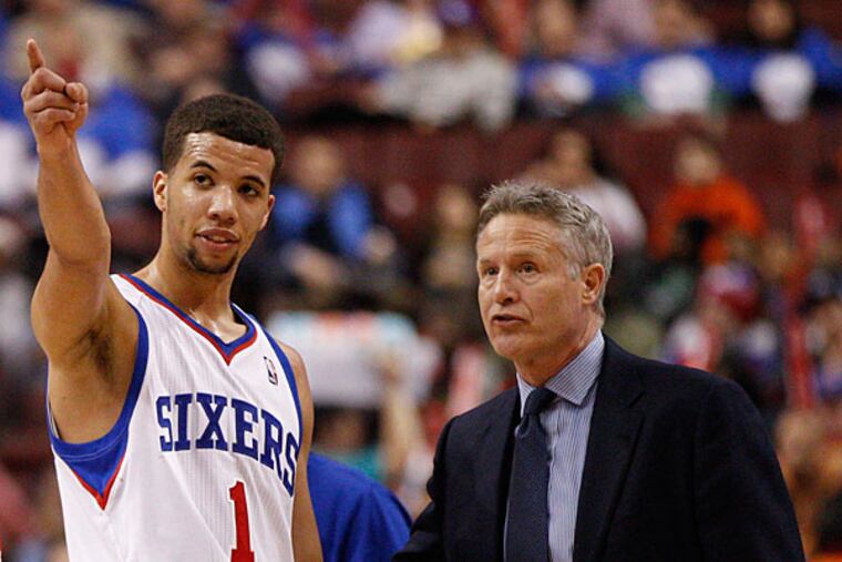 Michael Carter-Williams, left, points things out to head coach Brett Brown. (Chris Szagola/AP file)