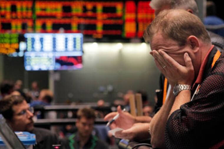 ADVANCE FOR USE FRIDAY, DEC. 30, AND THEREAFTER - FILE - In this Aug. 8, 2011 file photo, trader Andrew Stavros reacts after the close of trading in the NASDAQ 100 Index pit, on the floor of The CME Group in Chicago. Stocks plummeted at the close after anxiety overtook investors on the first trading day since Standard & Poor's downgraded American debt. The struggling Illinois economy was voted the No. 8 news story in Illinois for 2011 by members of The Associated Press and the wire service's staff. (AP Photo/M. Spencer Green, File)