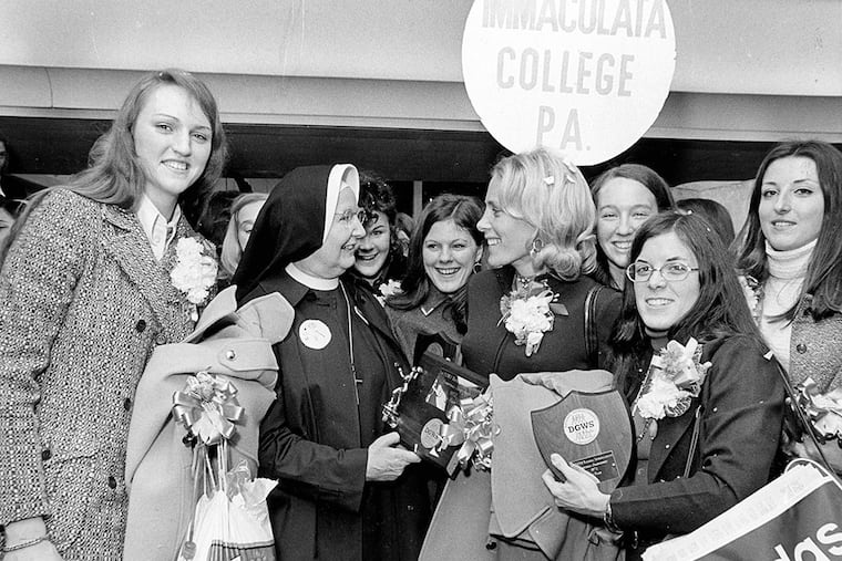 Members of the Immaculata College women's basketball team gather around their coach as they return after winning the first women's collegiate national champions in 1972. From left to right in the foreground are Theresa Shank, college president Sister Mary of Lourdes, women's basketball coach Cathy Rush and Janet Ruch.