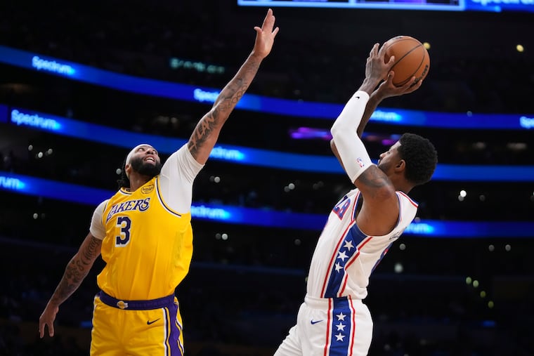 Sixers' Paul George (right) shoots over Los Angeles Lakers forward Anthony Davis during Friday night's matchup.