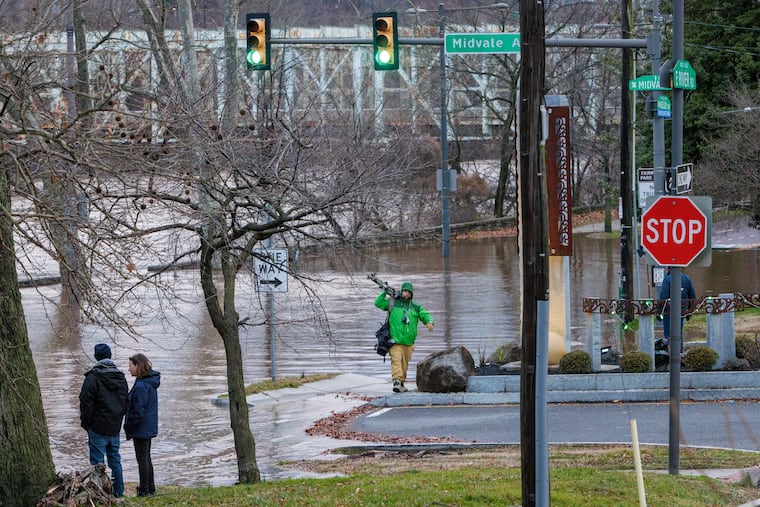 Residents and media along Kelly drive at the bank of the Schuylkill River has flooded at the bottom of Midvale in East Falls section of Philadelphia on Wednesday.