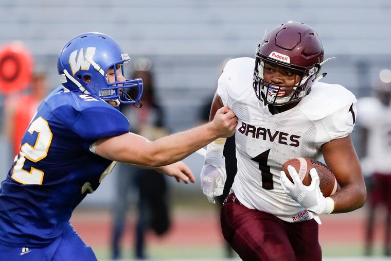 Bartram High's Jibril Pollard runs with the football against Washington High's James Dalton during the first-quarter.