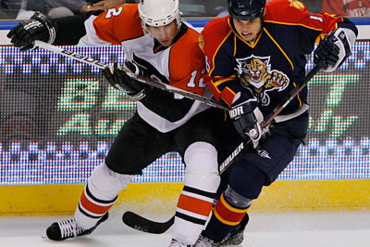 Simon Gagne and Florida Panthers center Nathan Horton battle for the puck during the first period yesterday. (AP Photo/Wilfredo Lee)