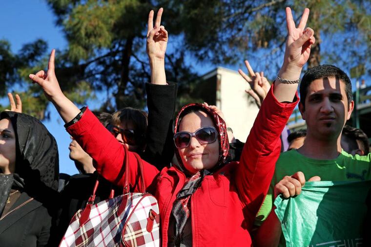 Iranians flash the victory sign while waiting for arrival of Foreign Minister Mohammad Javad Zarif from Lausanne, Switzerland, at the Mehrabad airport in Tehran, Iran, Friday, April 3, 2015. Iran and six world powers reached a preliminary nuclear agreement Thursday outlining commitments by both sides as they work for a comprehensive deal aiming at curbing nuclear activities Tehran could use to make weapons and providing sanctions relief for Iran. (AP Photo/Ebrahim Noroozi)