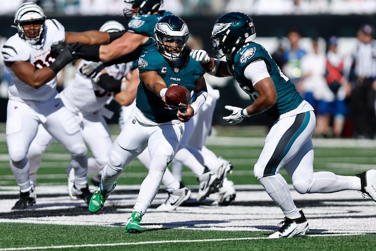 Eagles quarterback Jalen Hurts hands off the football to Saquon Barkley during their game on Sunday against the Cincinnati Bengals.