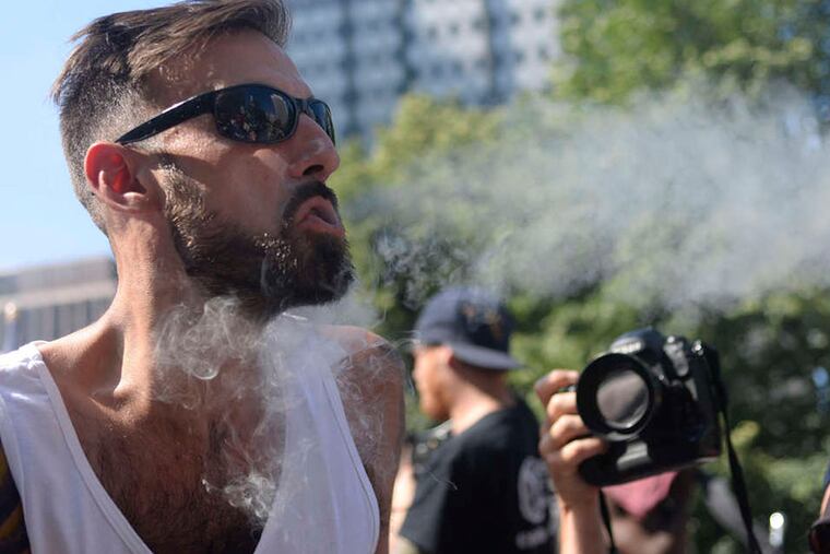 N.A. Poe blows smoke into the crowd gathered for a pot-legalization rally at LOVE Park. BEN MIKESELL / STAFF PHOTOGRAPHER