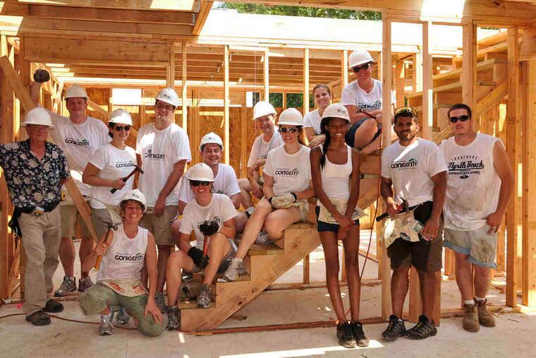 Conigent's Ameet Shah (second from right) and his wife, Shannon, (seated on bottom step) join employees, friends, and relatives at a Habitat for Humanity site.