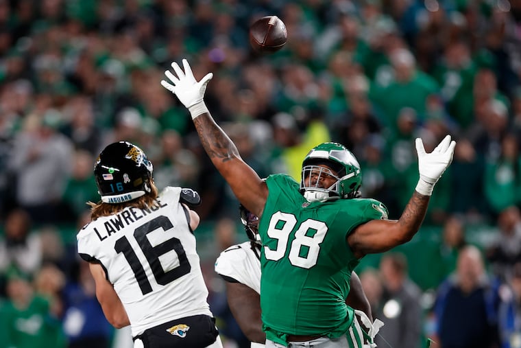 Eagles defensive tackle Jalen Carter reaches after the football against Jacksonville Jaguars quarterback Trevor Lawrence on Sunday. Carter, who's in his second season, had one of the best games of his career on Sunday.