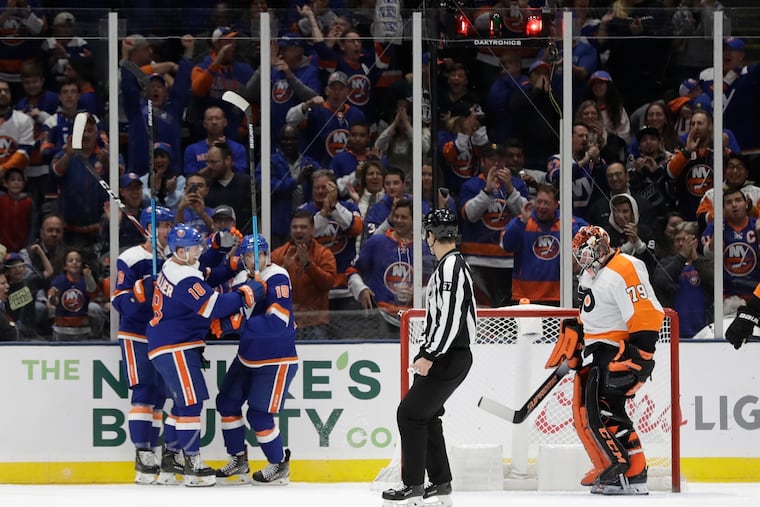 Flyers goaltender Carter Hart reacts as the New York Islanders celebrate a goal by Derick Brassard during the first period.