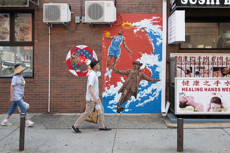 Pedestrians walk past Chenlin Cai's new LeBron James mural at 10th and Arch Streets in Philadelphia’s Chinatown on Wednesday, Aug. 12, 2026.