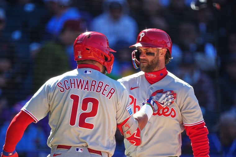 Bryce Harper (right) and Kyle Schwarber each hit home runs in the Phillies' rout of the Rockies on Friday.