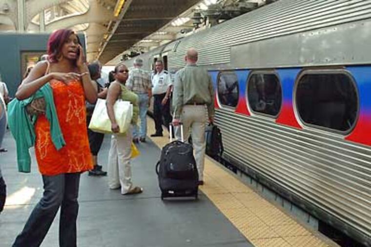 At 30th Street Station, a woman talks on her cell phone while waiting to board a train. SEPTA will begin offering a "quiet car" on the R5 where riders can escape cell-phone chatter. (Sharon Gekoski-Kimmel / Staff File Photo)