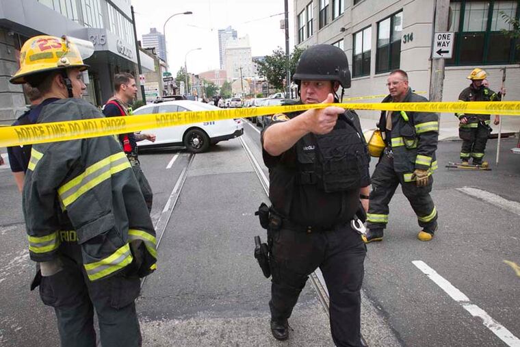 Philadelphia police near intersection of N. 12th and Wood where a suspicious device was destroyed by bomb squad during investigation on Friday, August 1, 2014. ALEJANDRO A. ALVAREZ / Staff Photographer